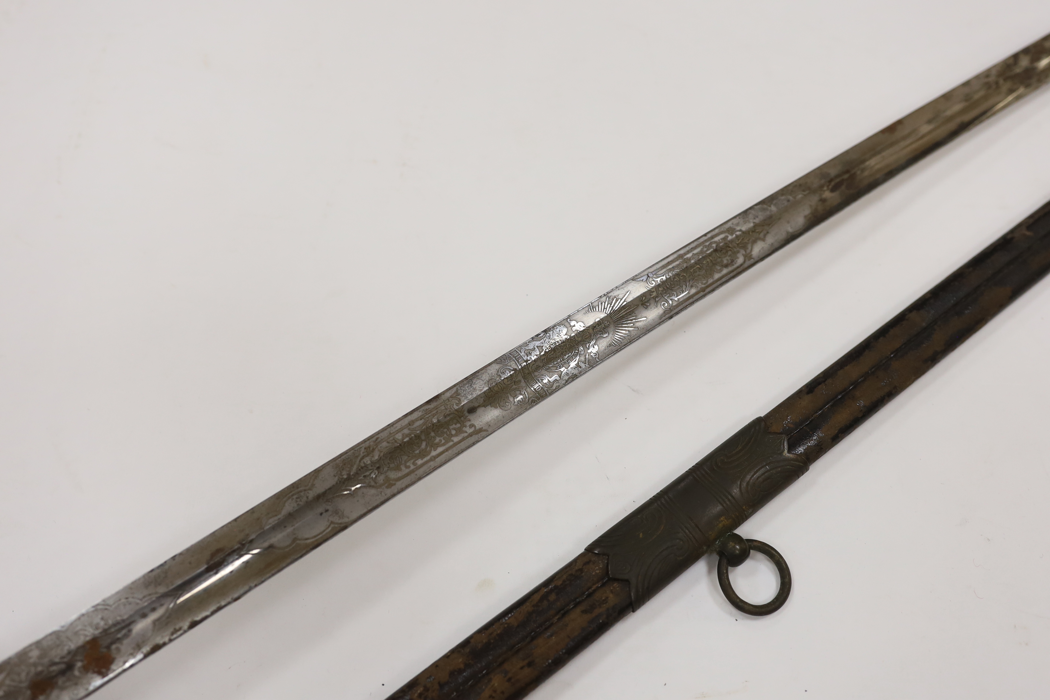 A late Victorian naval officer’s sword of the Royal Naval Reserve, regulation hilt with folding guard and bullion dress knot, in its leather scabbard with brass mounts